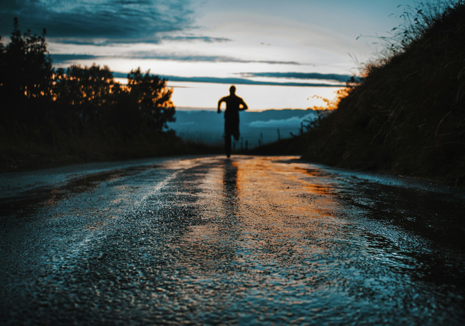 Runner on an asphalt road during sunrise