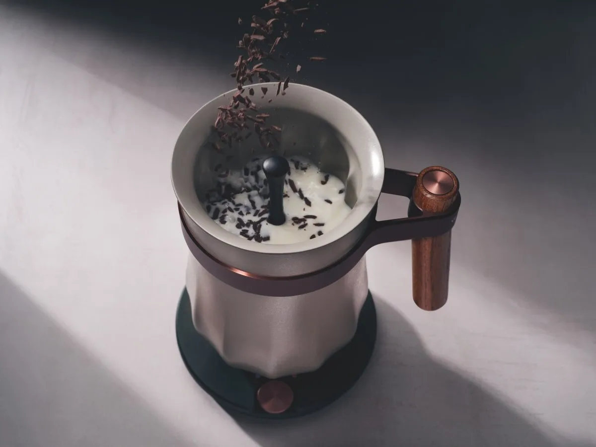 Chocolate flakes falling into warm milk inside the Hotel Chocolat Velvetiser as the whisk spins