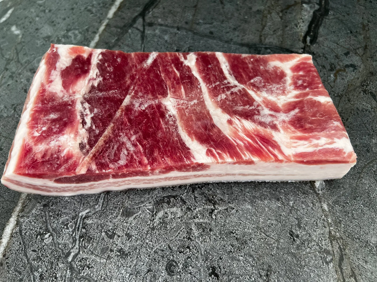 Cordobes Foods Pork Belly Skin-On Slab, raw with skin and fat layers visible