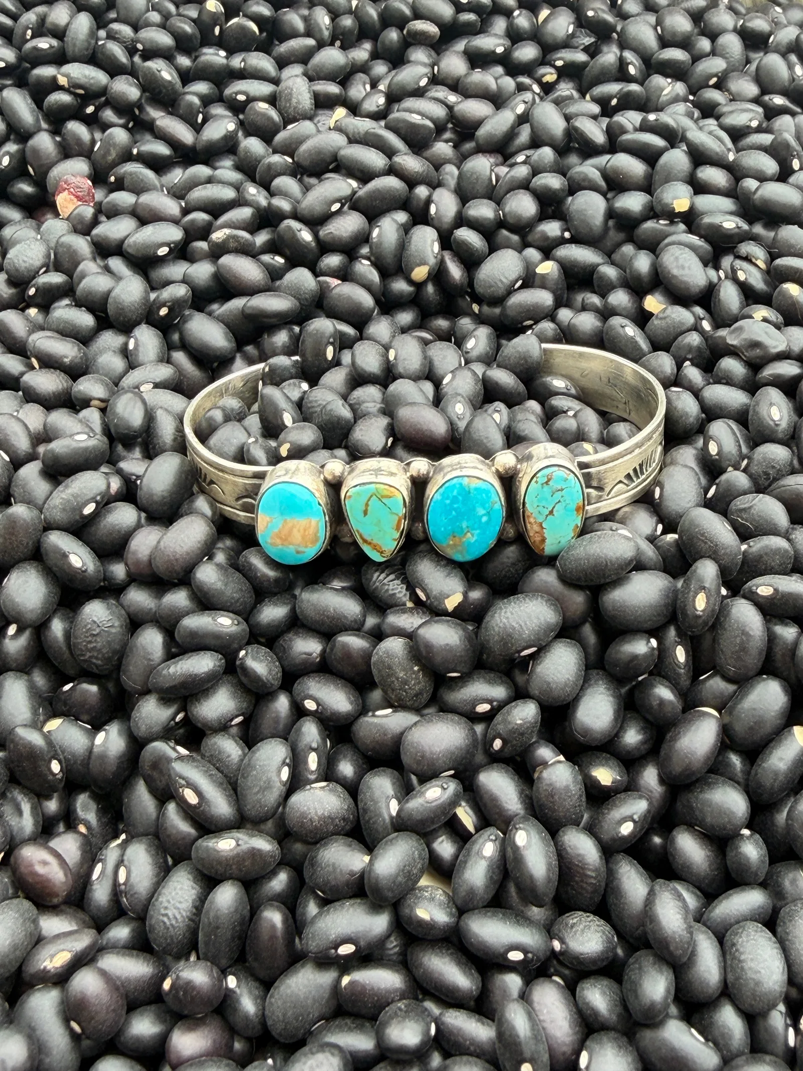 Flat lay of turquoise jewelry, concho belt and felt hat for cowgirl style
