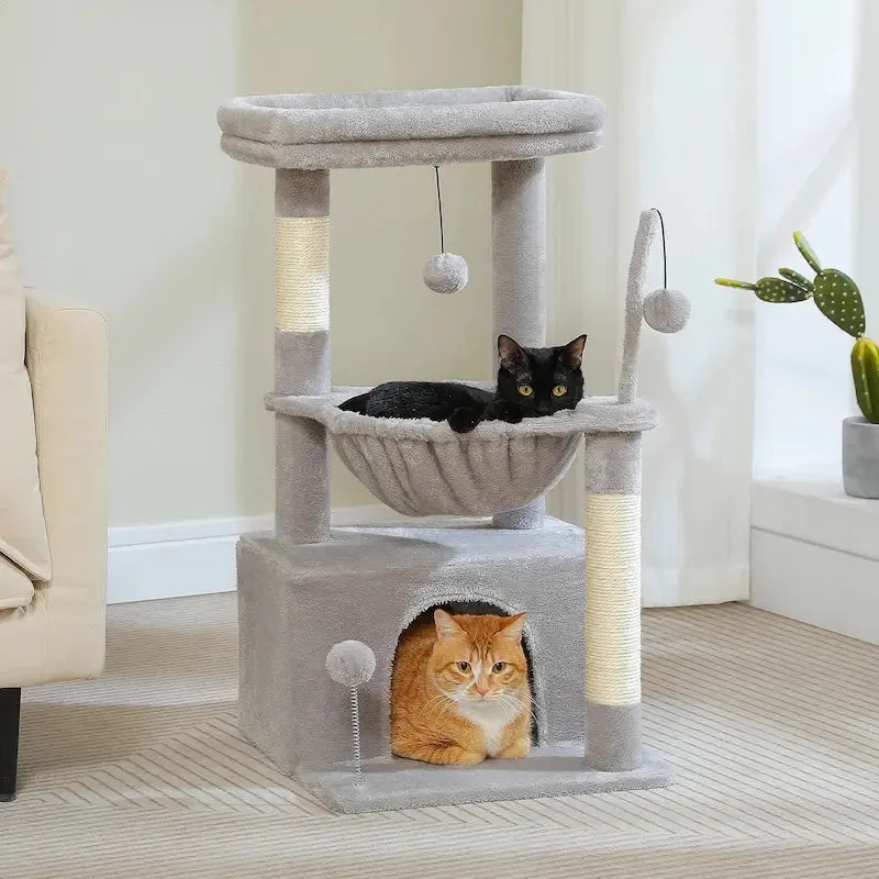 two cats sharing separate levels of a Griffe d'Amour cat tree next to a litter box in a multi-cat home