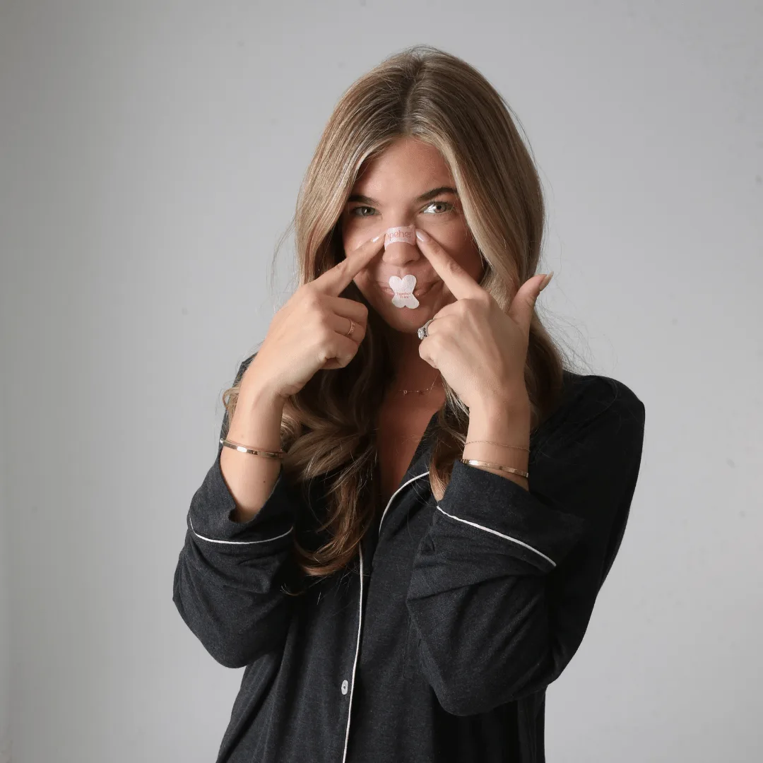 Does mouth tape help with snoring: a person applying a Tapeher nose strip across the bridge of the nose, with X-shaped mouth tape below