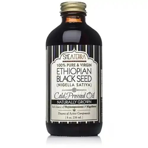 Shea Terra Organics rosehip seed oil bottle next to fresh rosehips